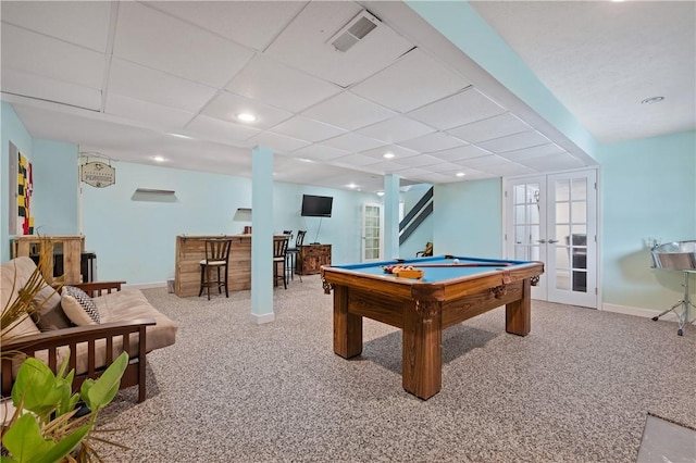 recreation room featuring carpet, a paneled ceiling, french doors, and bar