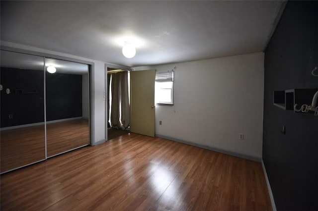 unfurnished bedroom with hardwood / wood-style flooring and a closet