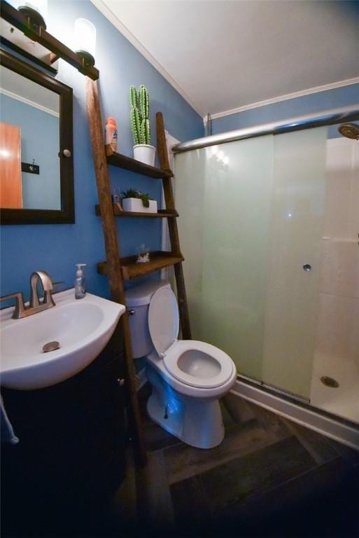 bathroom featuring toilet, a shower with door, crown molding, and vanity