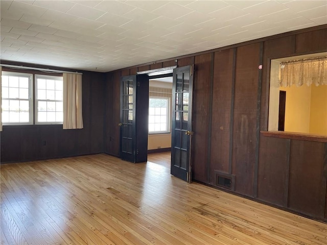 empty room featuring light hardwood / wood-style floors and wood walls