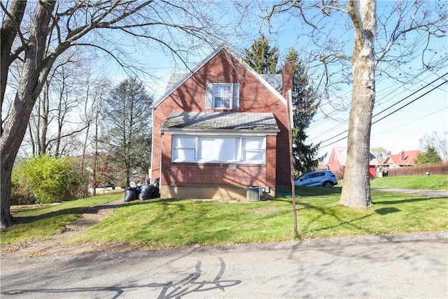 view of front of property with a front yard and central air condition unit