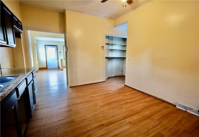 kitchen with ceiling fan, sink, and light wood-type flooring