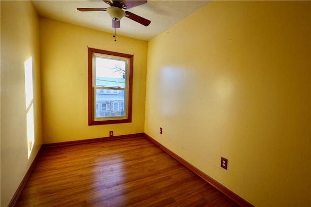 spare room featuring ceiling fan, a healthy amount of sunlight, and wood-type flooring