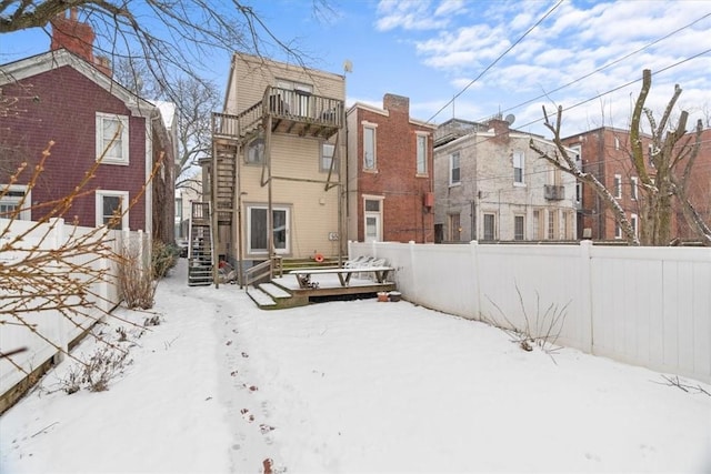 snow covered property featuring a balcony