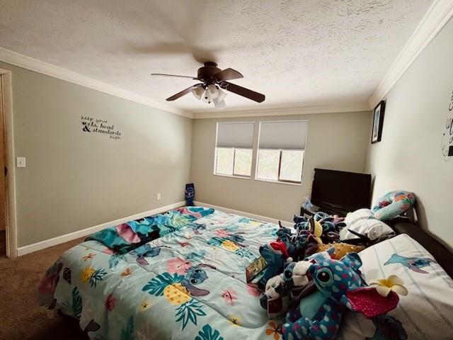 bedroom featuring ceiling fan, crown molding, a textured ceiling, and carpet