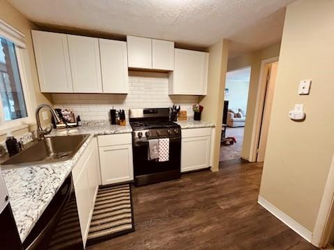 kitchen with white cabinetry, stainless steel range with gas cooktop, dark hardwood / wood-style flooring, and sink