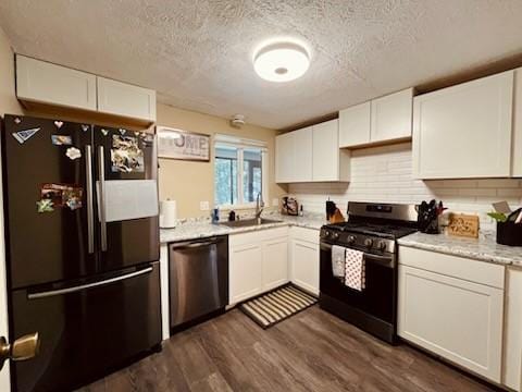 kitchen featuring dishwasher, black fridge, white cabinets, and gas range