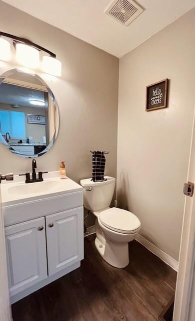 bathroom featuring vanity, toilet, and hardwood / wood-style floors