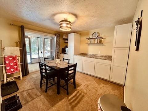 dining room featuring light carpet and a textured ceiling