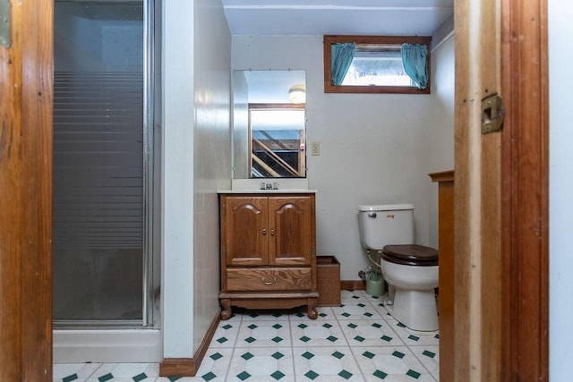 bathroom with toilet, a shower with door, and vanity