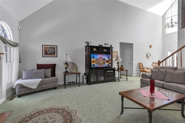 carpeted living room with a chandelier and high vaulted ceiling