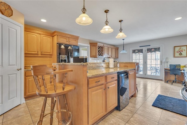 kitchen with light stone countertops, pendant lighting, light tile patterned floors, and an island with sink