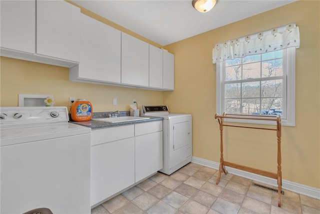 laundry room featuring cabinets, washer and dryer, and sink