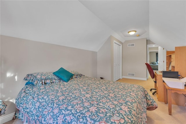 carpeted bedroom with a closet and vaulted ceiling