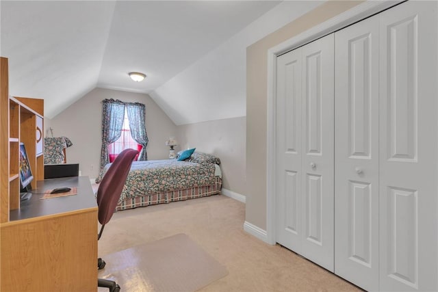 carpeted bedroom with a closet and vaulted ceiling