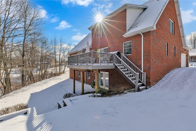 snow covered property with a wooden deck