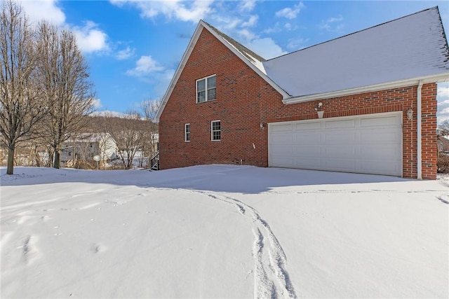 view of snowy exterior with a garage