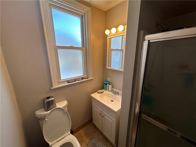 bathroom with toilet, plenty of natural light, and a shower with door