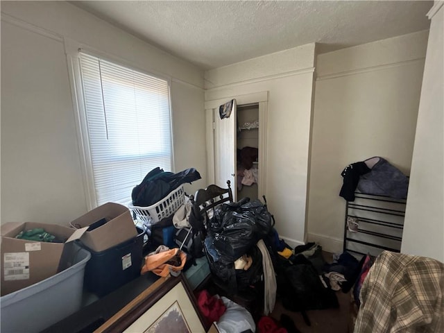 bedroom with a closet, a textured ceiling, and multiple windows