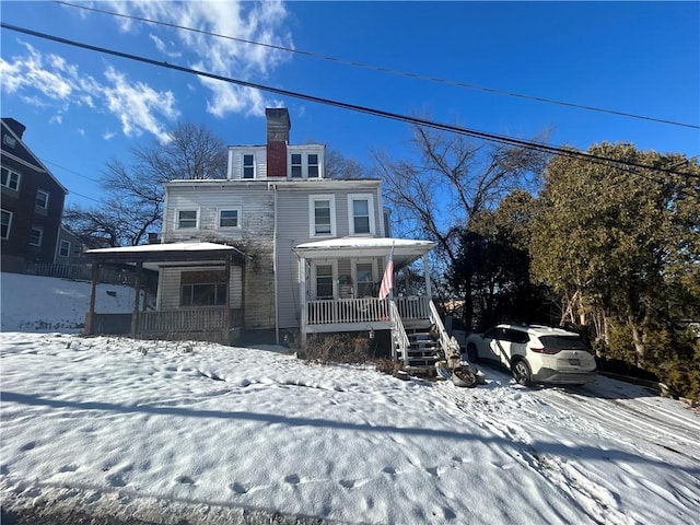 snow covered property featuring covered porch