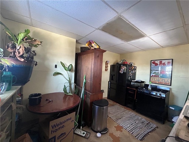 kitchen with black fridge, a paneled ceiling, and dishwashing machine