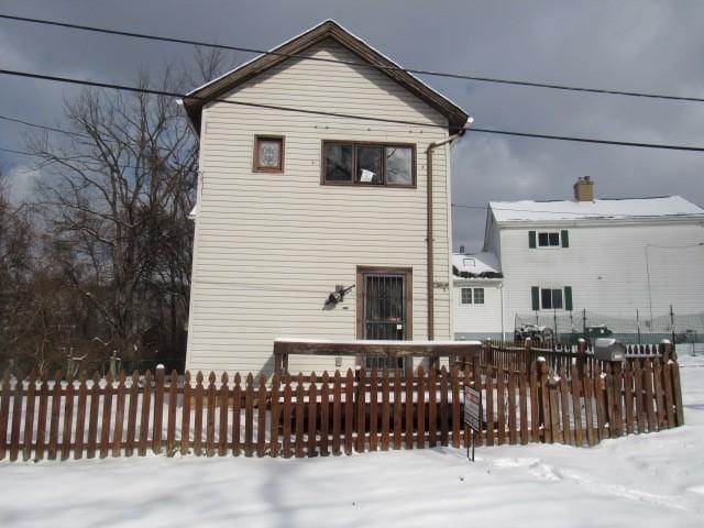 view of snow covered back of property