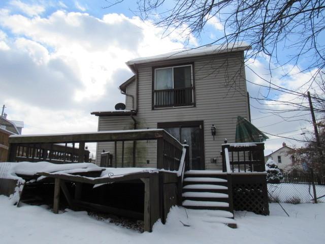 snow covered house with a deck