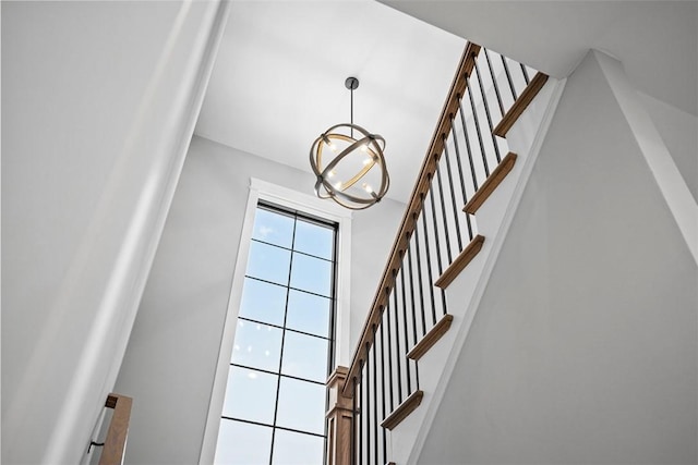 stairs with an inviting chandelier