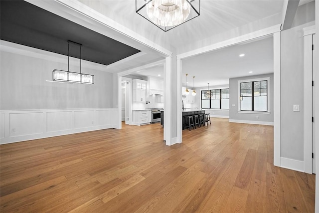 unfurnished living room featuring light hardwood / wood-style flooring and a notable chandelier