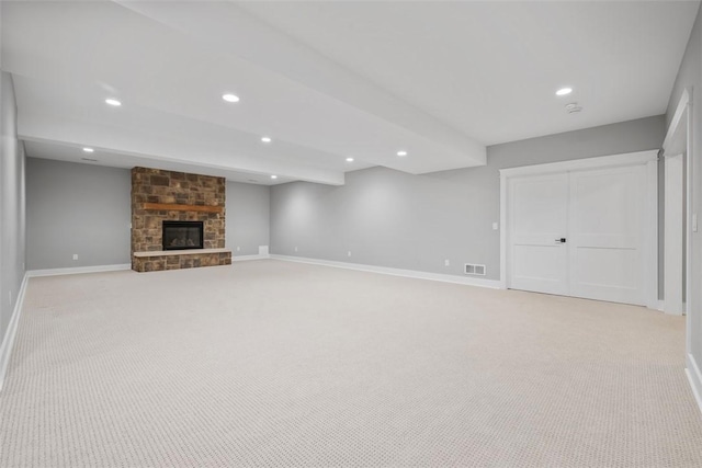 unfurnished living room with light colored carpet and a fireplace