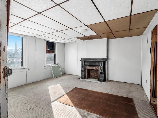 basement with light colored carpet and a paneled ceiling