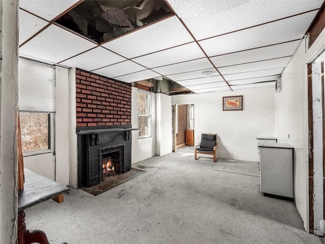 unfurnished living room with a drop ceiling and carpet flooring