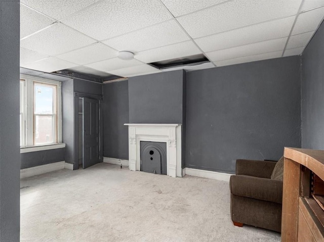 unfurnished living room with carpet floors and a paneled ceiling