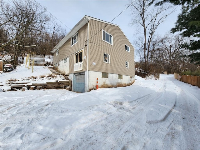 view of snow covered exterior with a garage