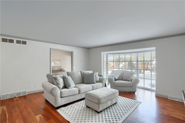 living room featuring crown molding and hardwood / wood-style flooring