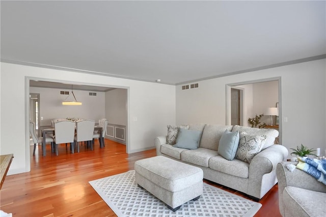 living room with ornamental molding and hardwood / wood-style flooring