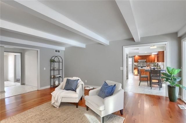 sitting room with beam ceiling and light hardwood / wood-style flooring