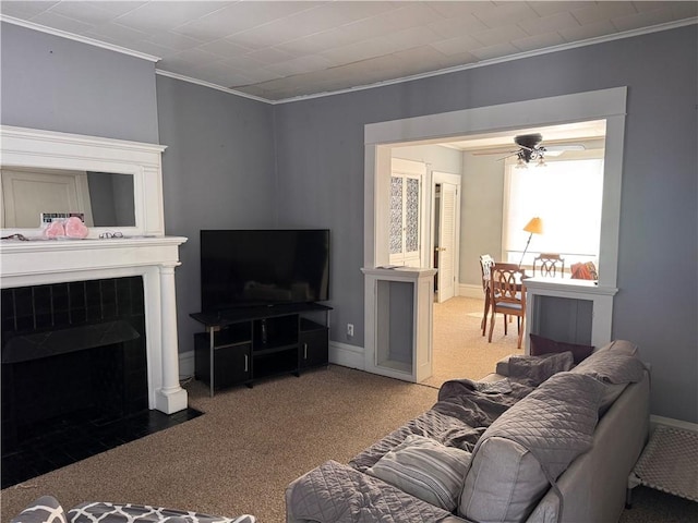 carpeted living room with ceiling fan and ornamental molding