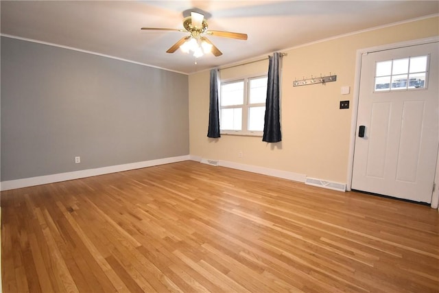 foyer entrance featuring light wood-type flooring, ceiling fan, and crown molding