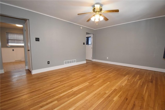 spare room featuring ceiling fan, crown molding, and light wood-type flooring