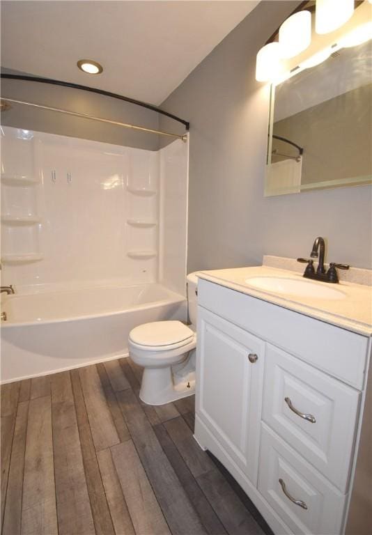 full bathroom featuring hardwood / wood-style flooring, tub / shower combination, toilet, and vanity