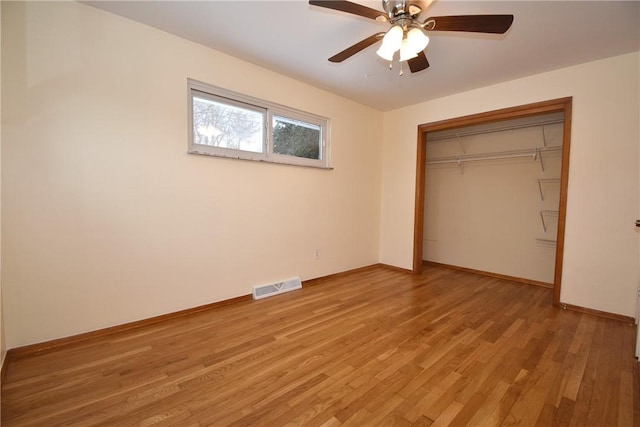 unfurnished bedroom with light wood-type flooring, ceiling fan, and a closet