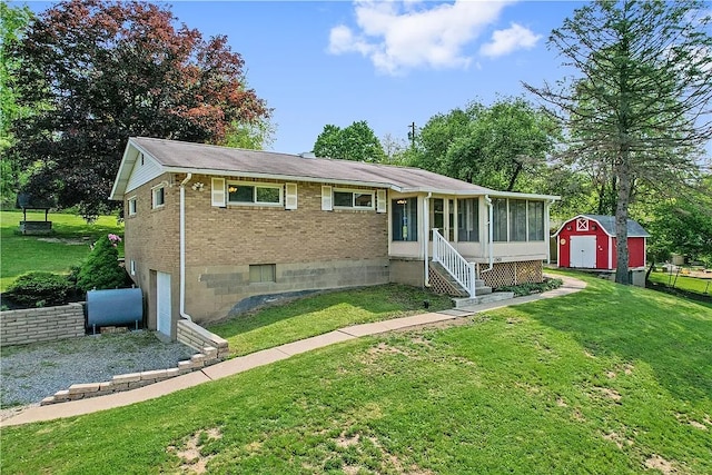 view of front of property featuring a front lawn, a storage shed, and a sunroom