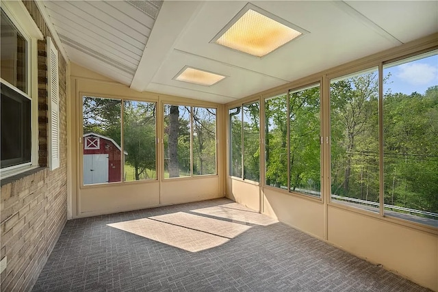 unfurnished sunroom featuring vaulted ceiling