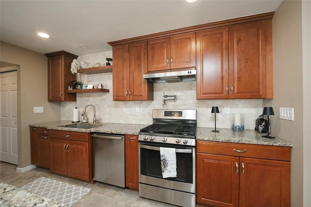 kitchen with stainless steel appliances, tasteful backsplash, sink, and light stone counters