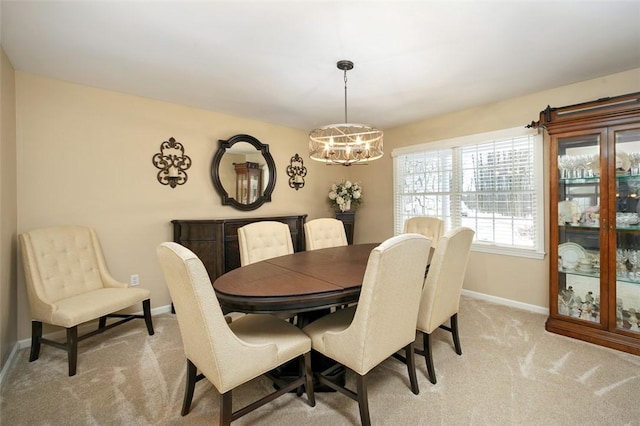 dining room featuring light carpet and a chandelier