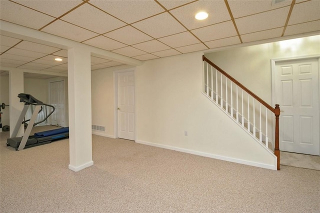 basement featuring a paneled ceiling and carpet