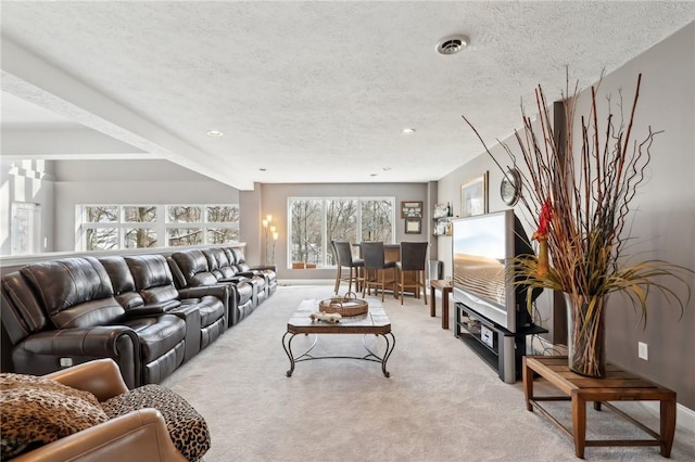 living room with light carpet, a textured ceiling, and beamed ceiling