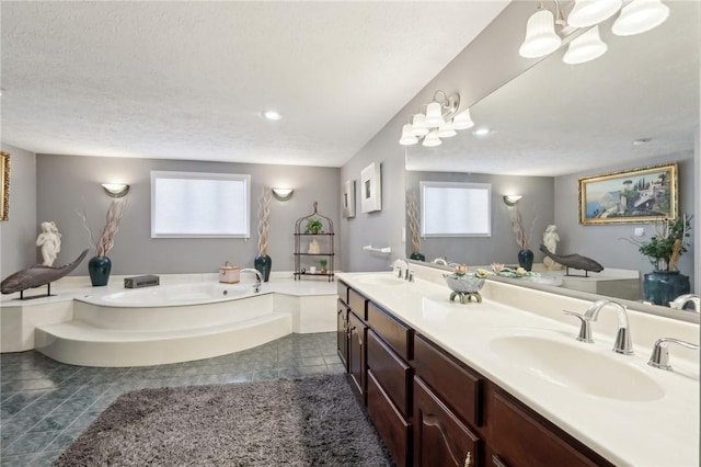 bathroom featuring vanity, tile patterned flooring, a washtub, and a textured ceiling