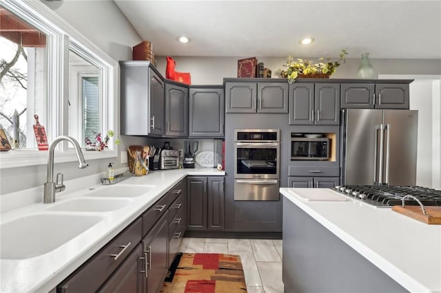 kitchen featuring a wealth of natural light, appliances with stainless steel finishes, sink, and light tile patterned floors